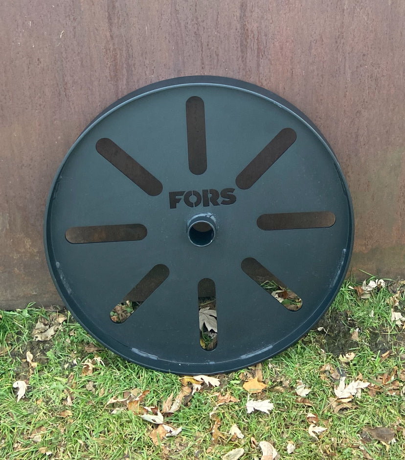 Metal reel with 'FORS' branding on grass and metal background