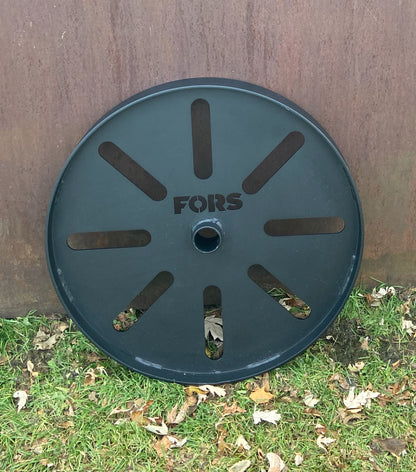 Metal reel with 'FORS' branding on grass and metal background